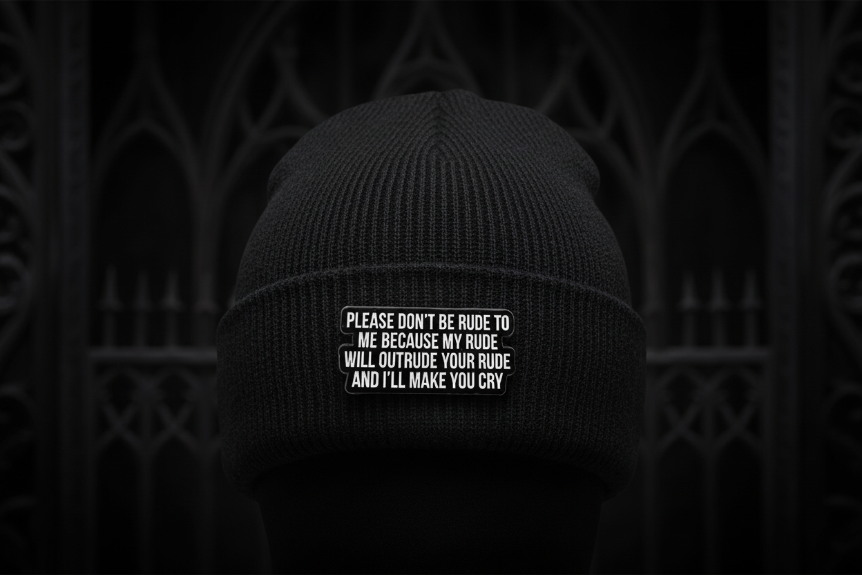 Black metal badge with white text on a black beanie background