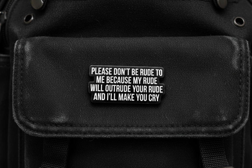 Black metal badge with white text on a black fabric background