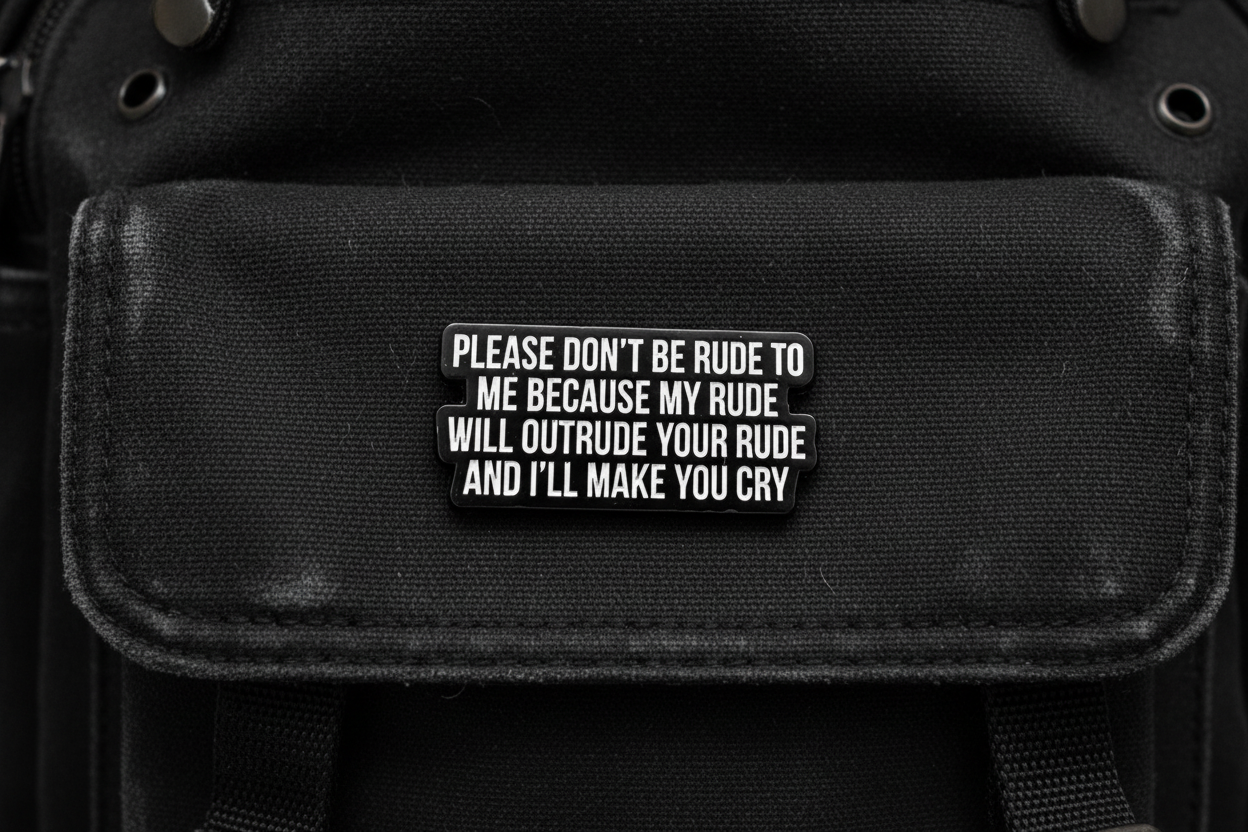Black metal badge with white text on a black fabric background