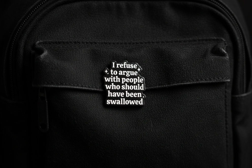 Black and white text pin on a black fabric background