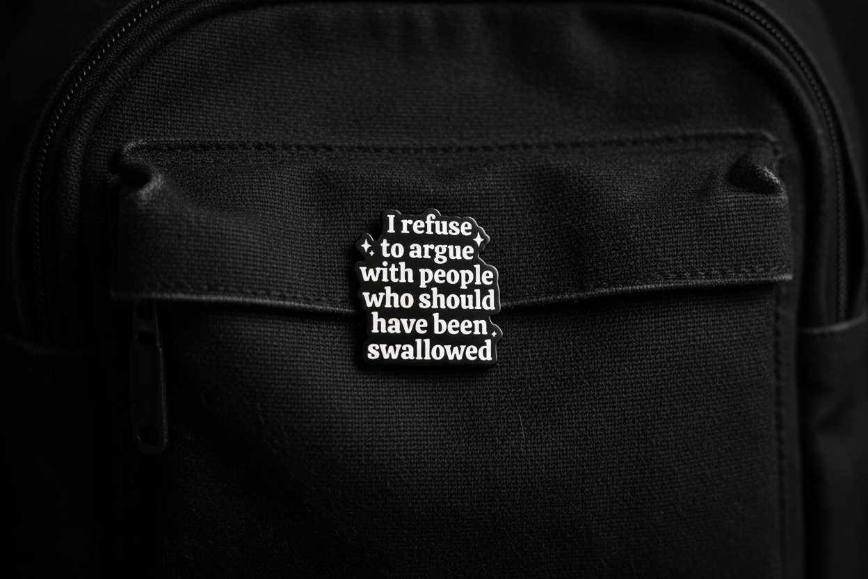 Black and white text pin on a black fabric background
