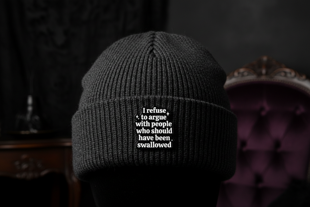 Black and white text pin on a black beanie hat background