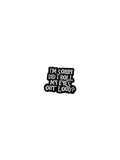 Black and white enamel pin with text on a gray background