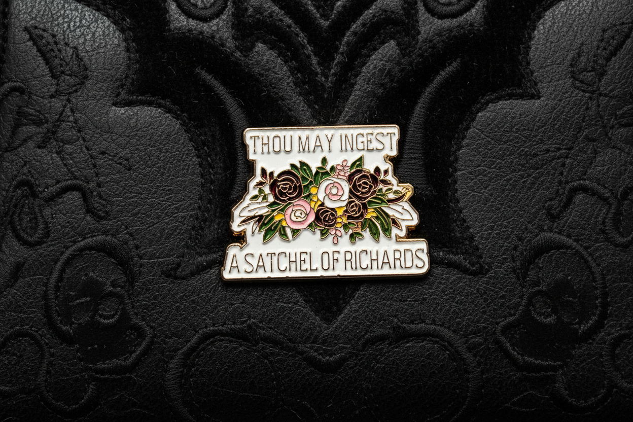 a enamel pin with text and a floral design on a black fabric background