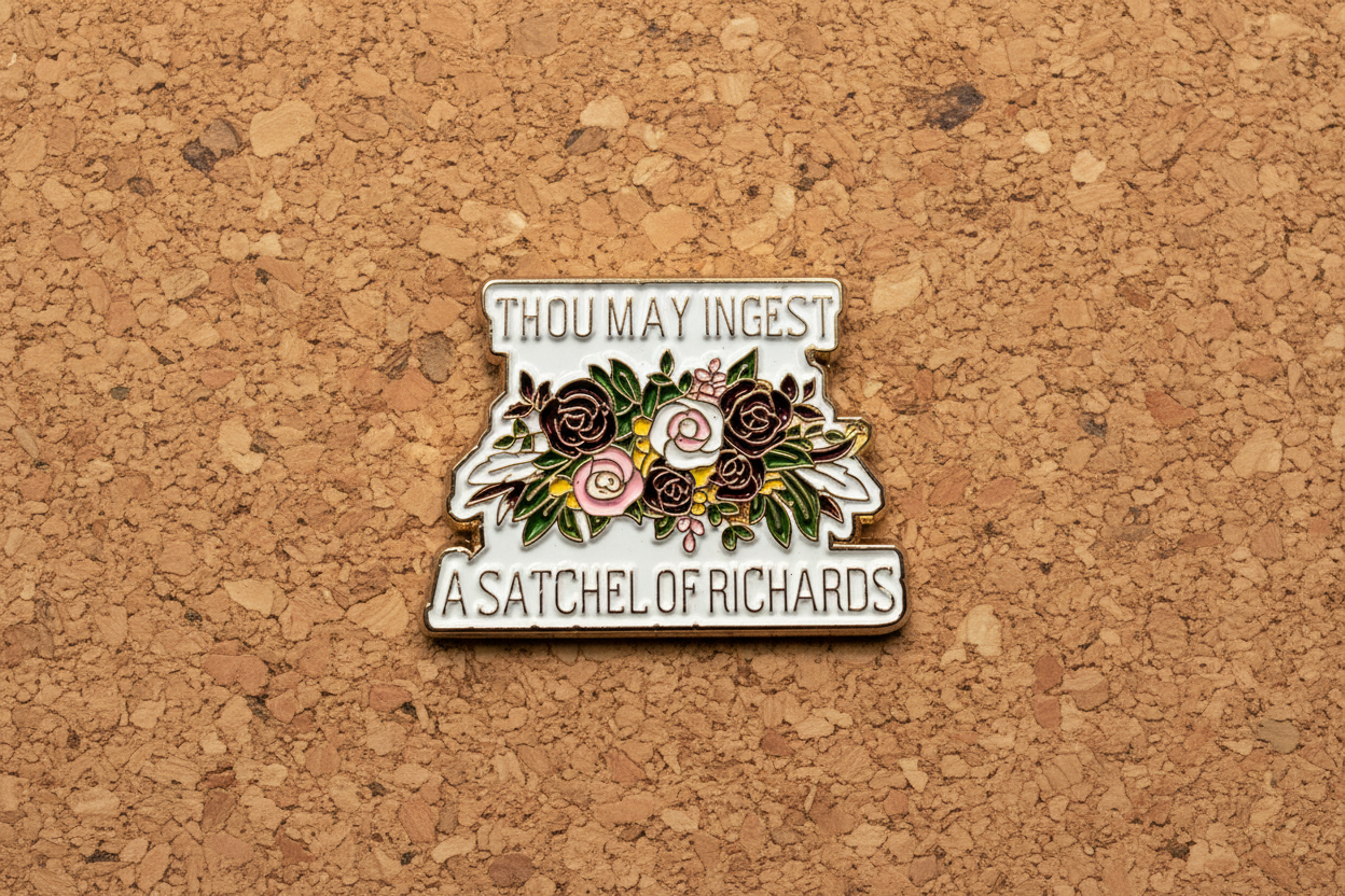 a enamel pin with text and a floral design on a cork background