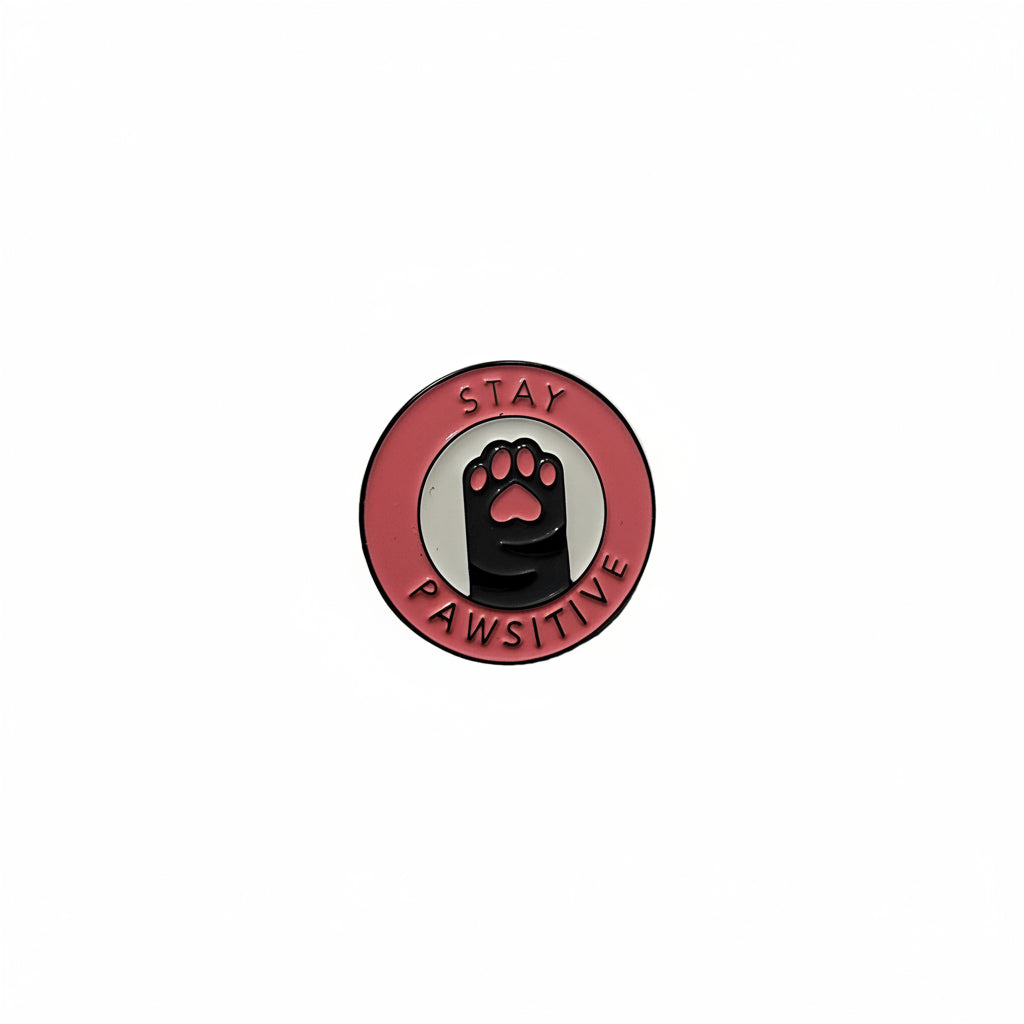 a circular enamel pin with a cat paw and text 