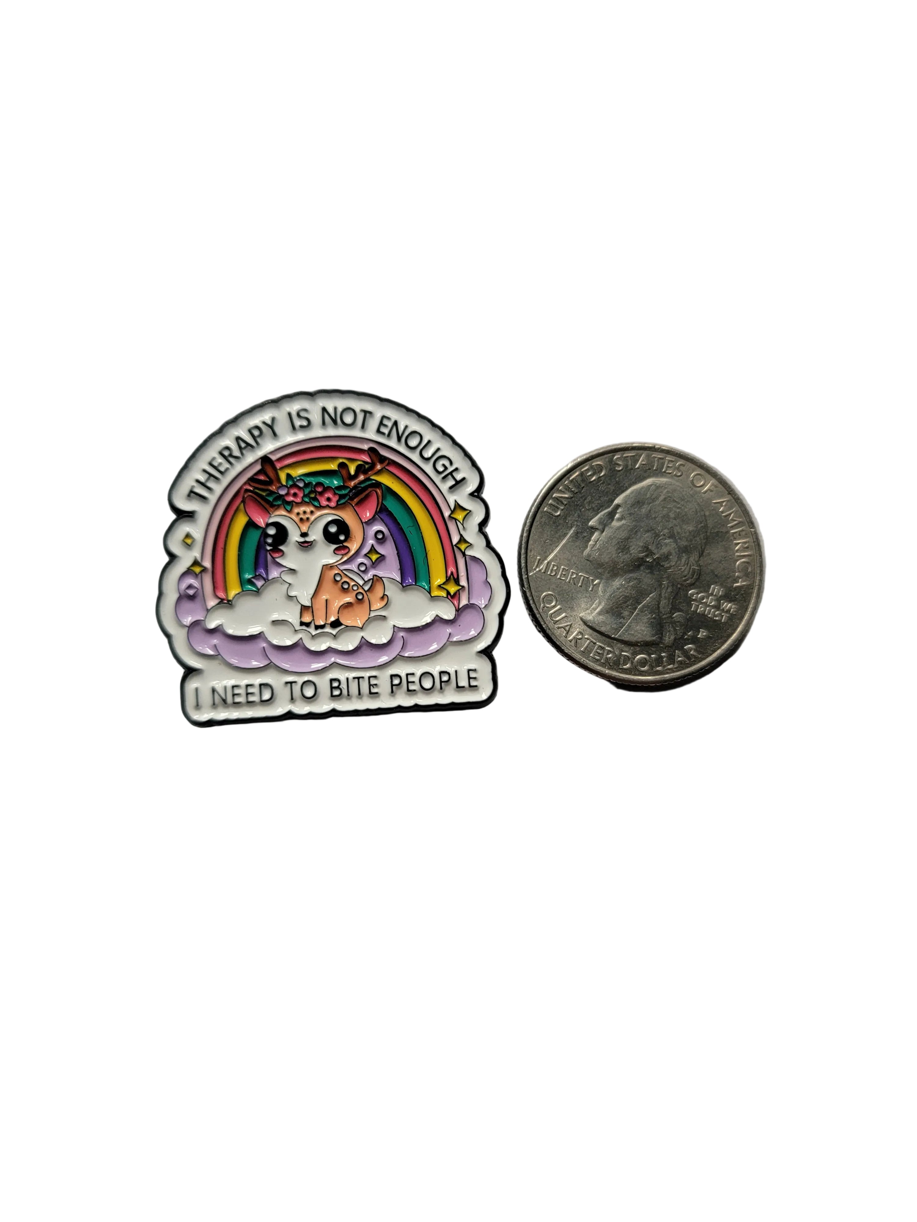 Small round pin with rainbow design and text next to a quarter on a gray background