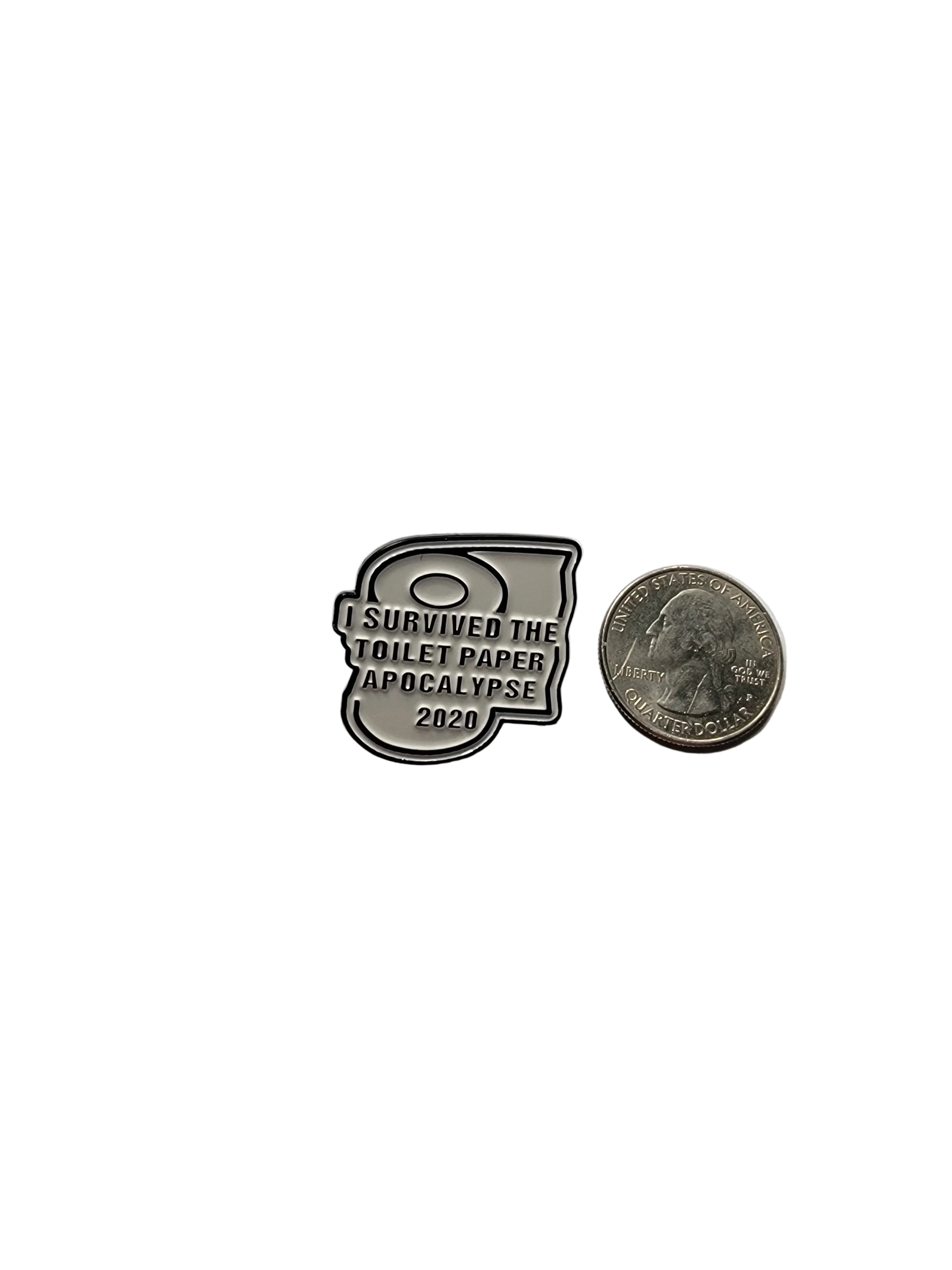 Metallic badge with text and a coin for scale on a light gray background