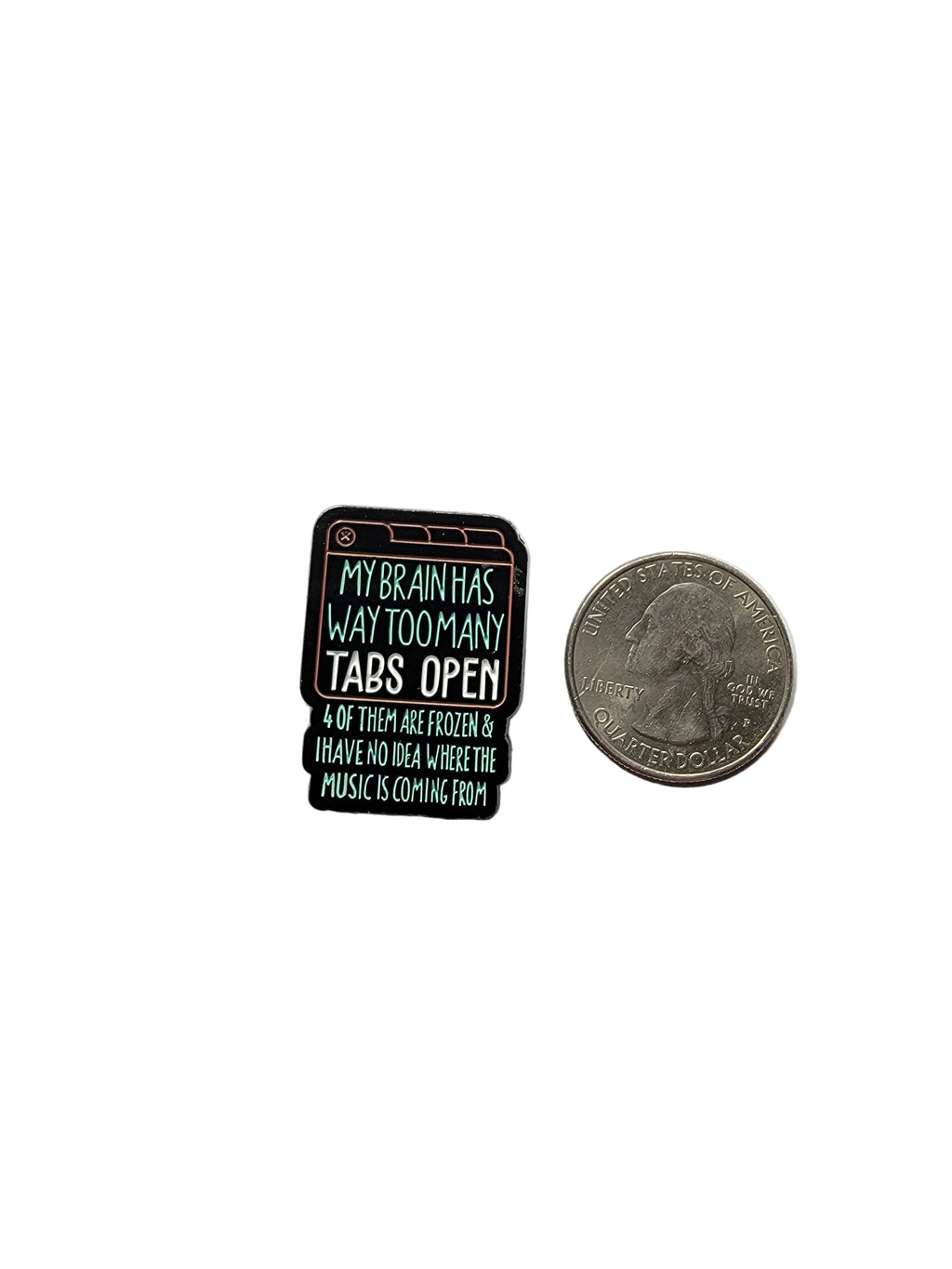 Small rectangular enamel pin with text next to a quarter on a gray background