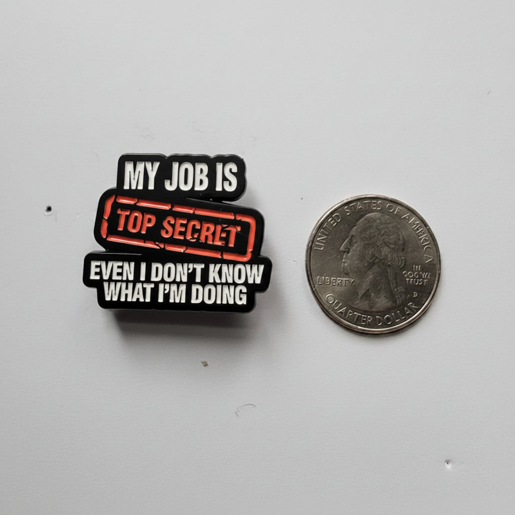 My job is top secret even I don't know what I'm doing even know what I am doing enamel pin shown next to quarter for size reference funny enamel pin dims on a gray background 1 1/8 in W x 1 in H