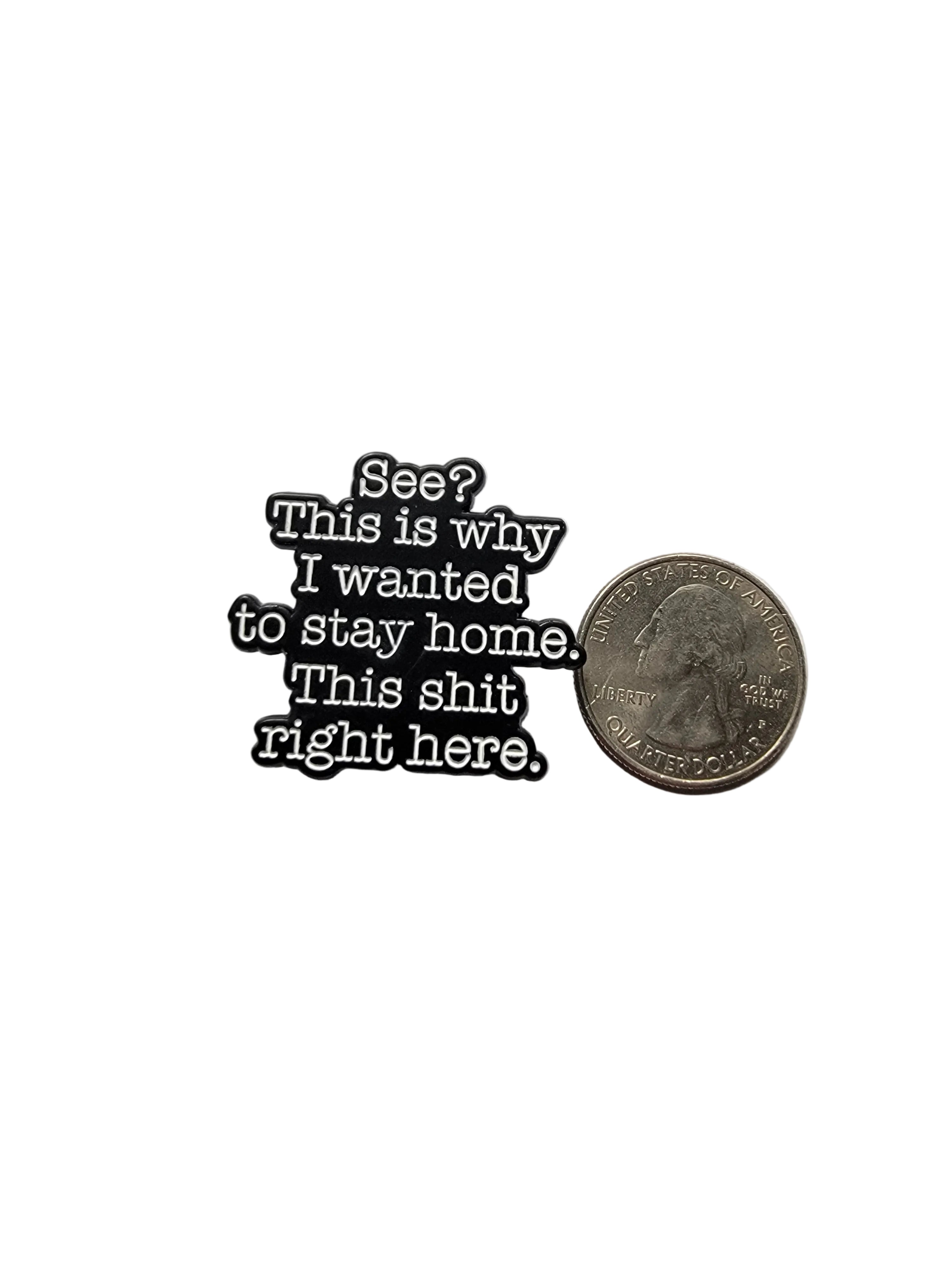 Small metal badge with text next to a quarter on a gray background