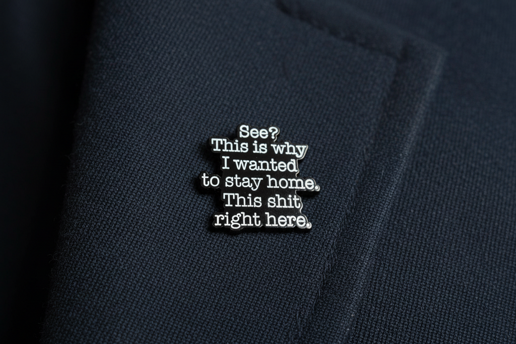 A black sarcastic pin with white text on a navy lapel background