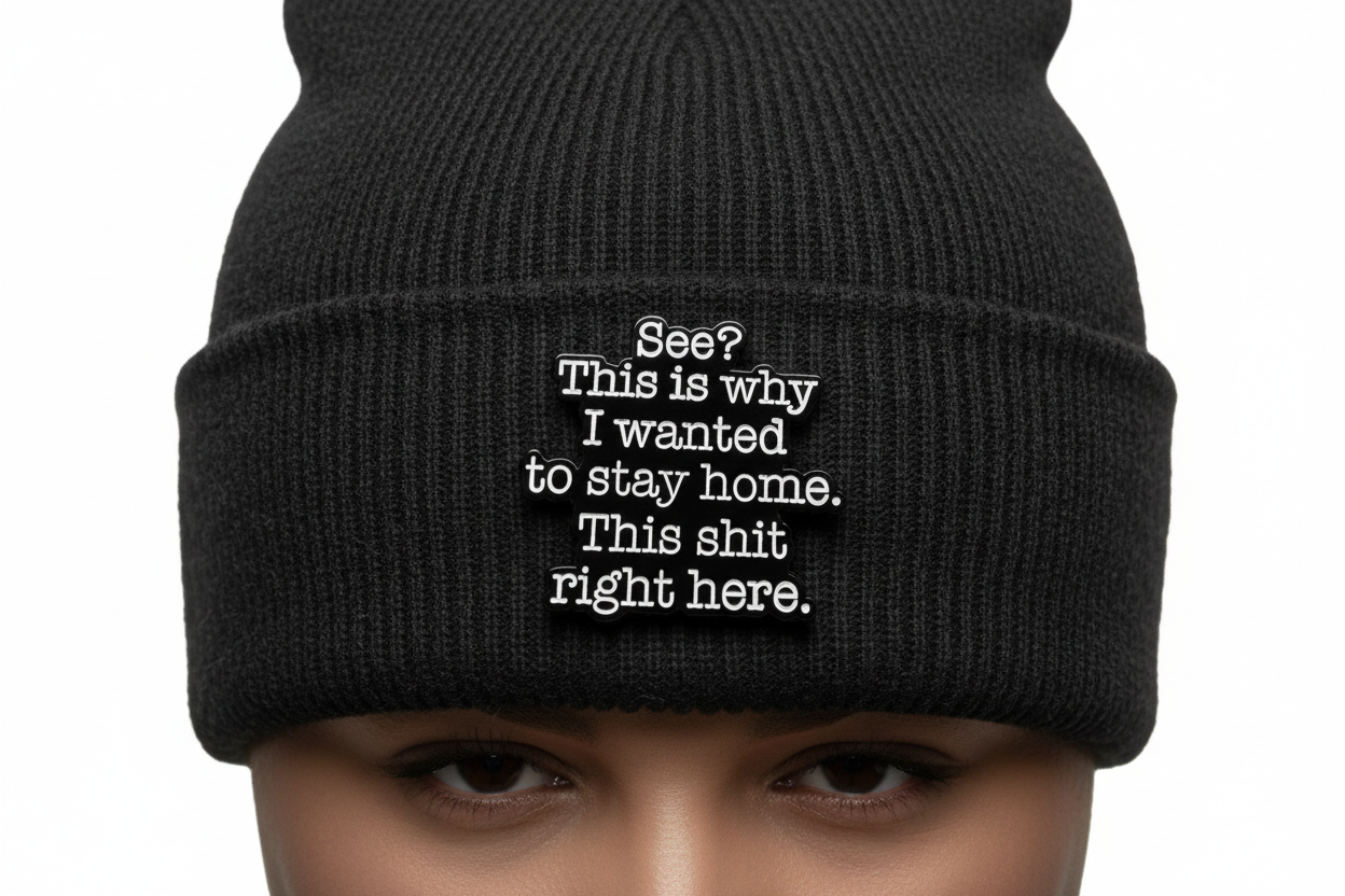 A black sarcastic pin with white text on a black beanie background