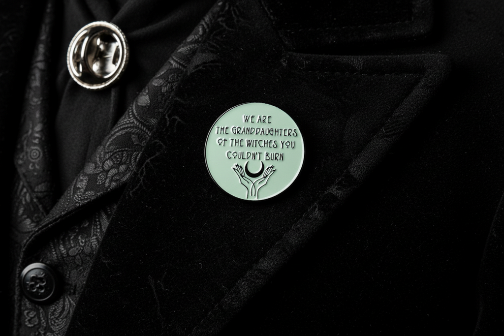 we are the granddaughters of the witches you couldn't burn enamel pin worn on jacket lapel, gothic accessory for everyday wear