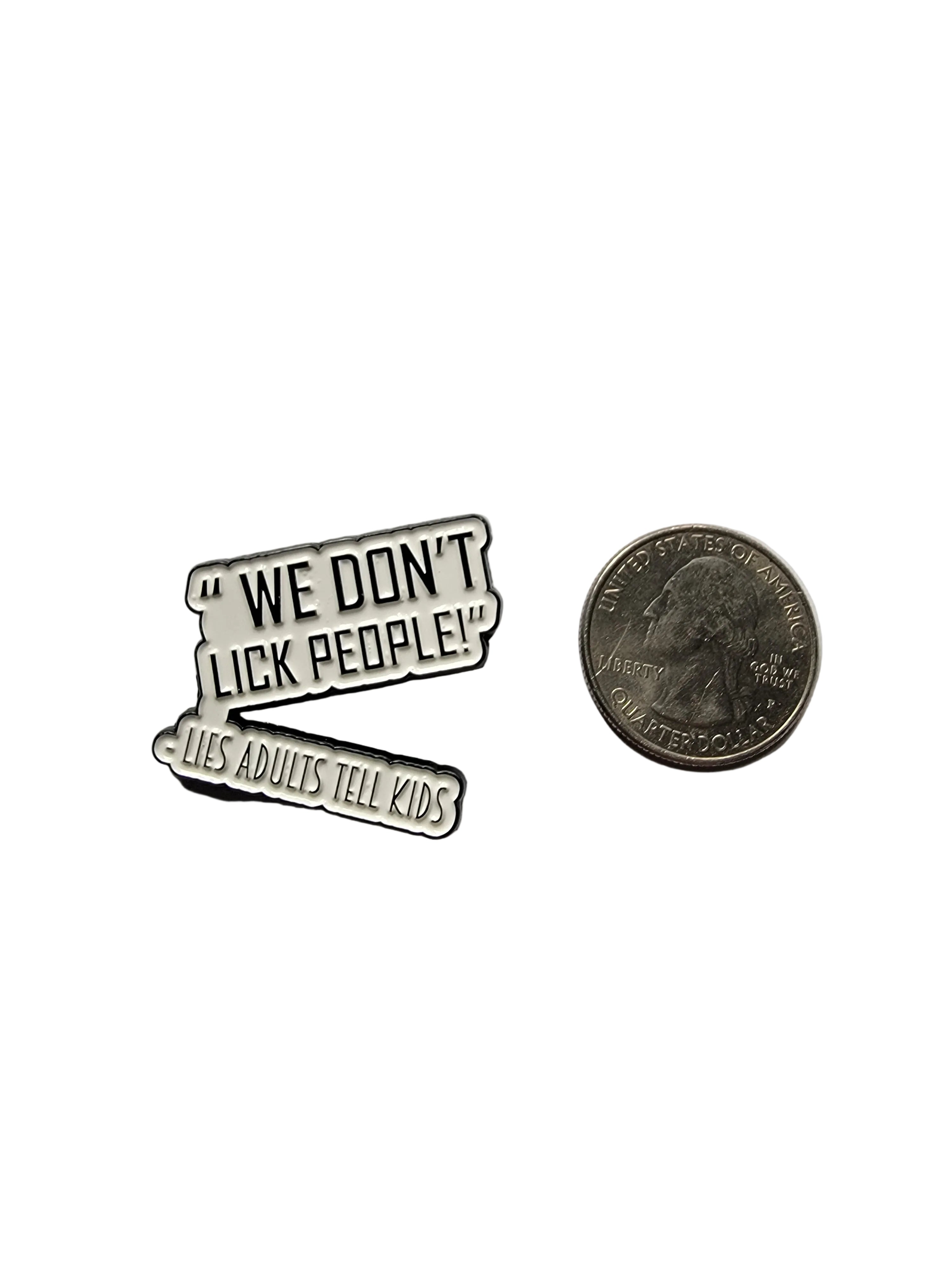 a white pin with black text next to a quarter for scale on a white background