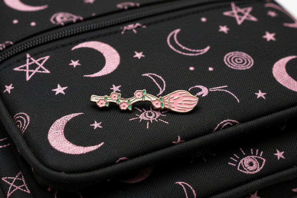 witchy broom enamel pin on backpack pastel goth accessory for customizing bags and school gear