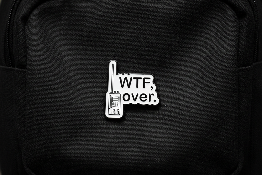 Pin with 'WTF over.' text on a black bookbag background