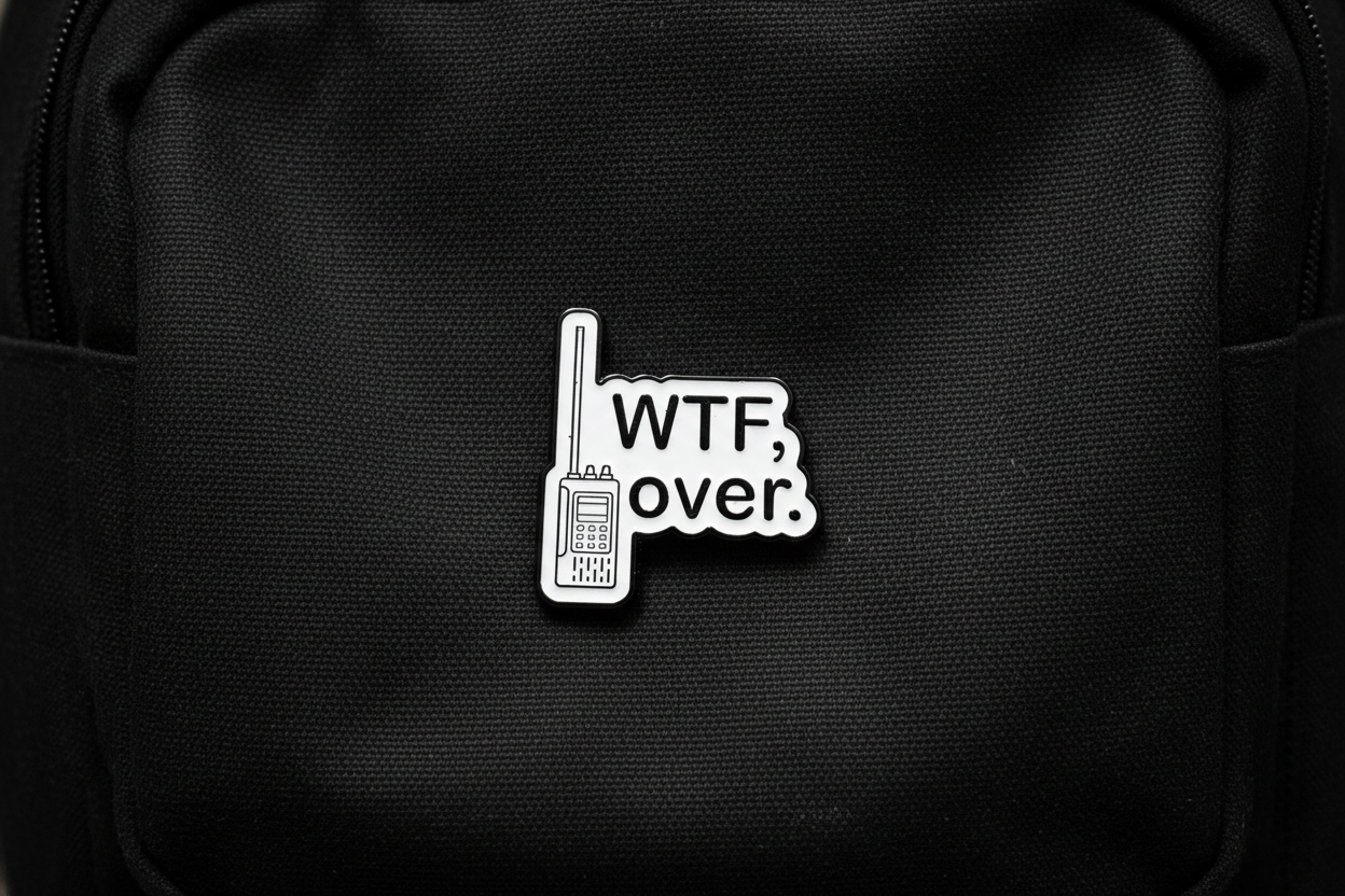 Pin with 'WTF over.' text on a black bookbag background